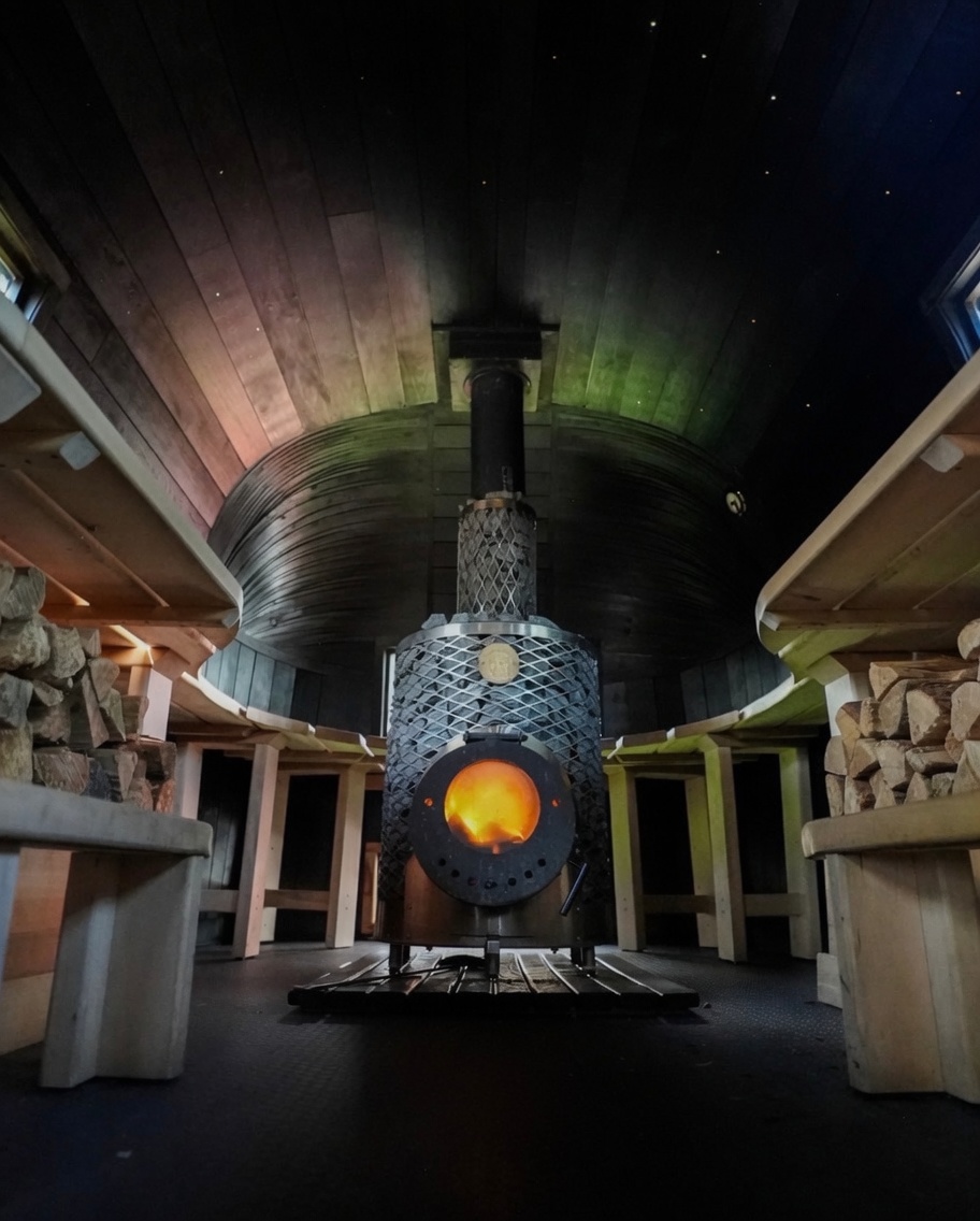 Inside the Casa Sauna with a glowing wood-fired stove